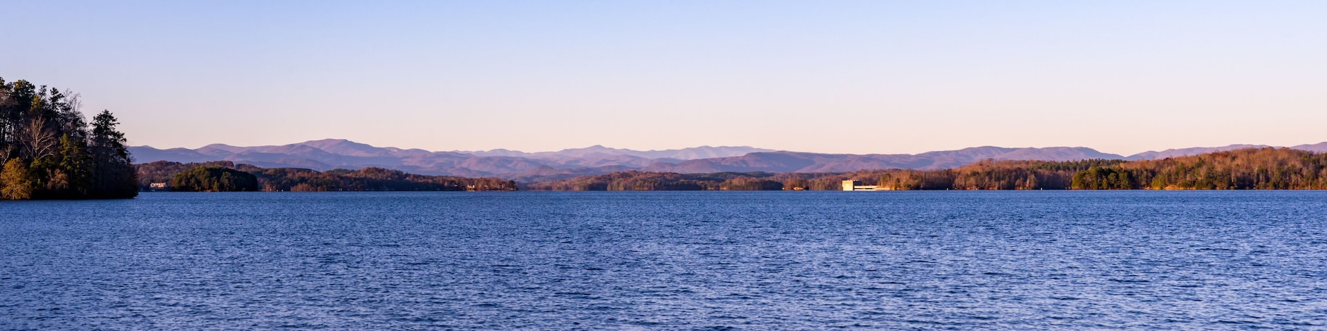 A calm lake with mountains in the background.