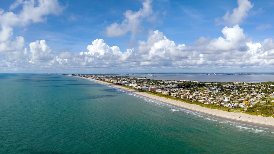 A coastal city with a beach, ocean, and scattered buildings.