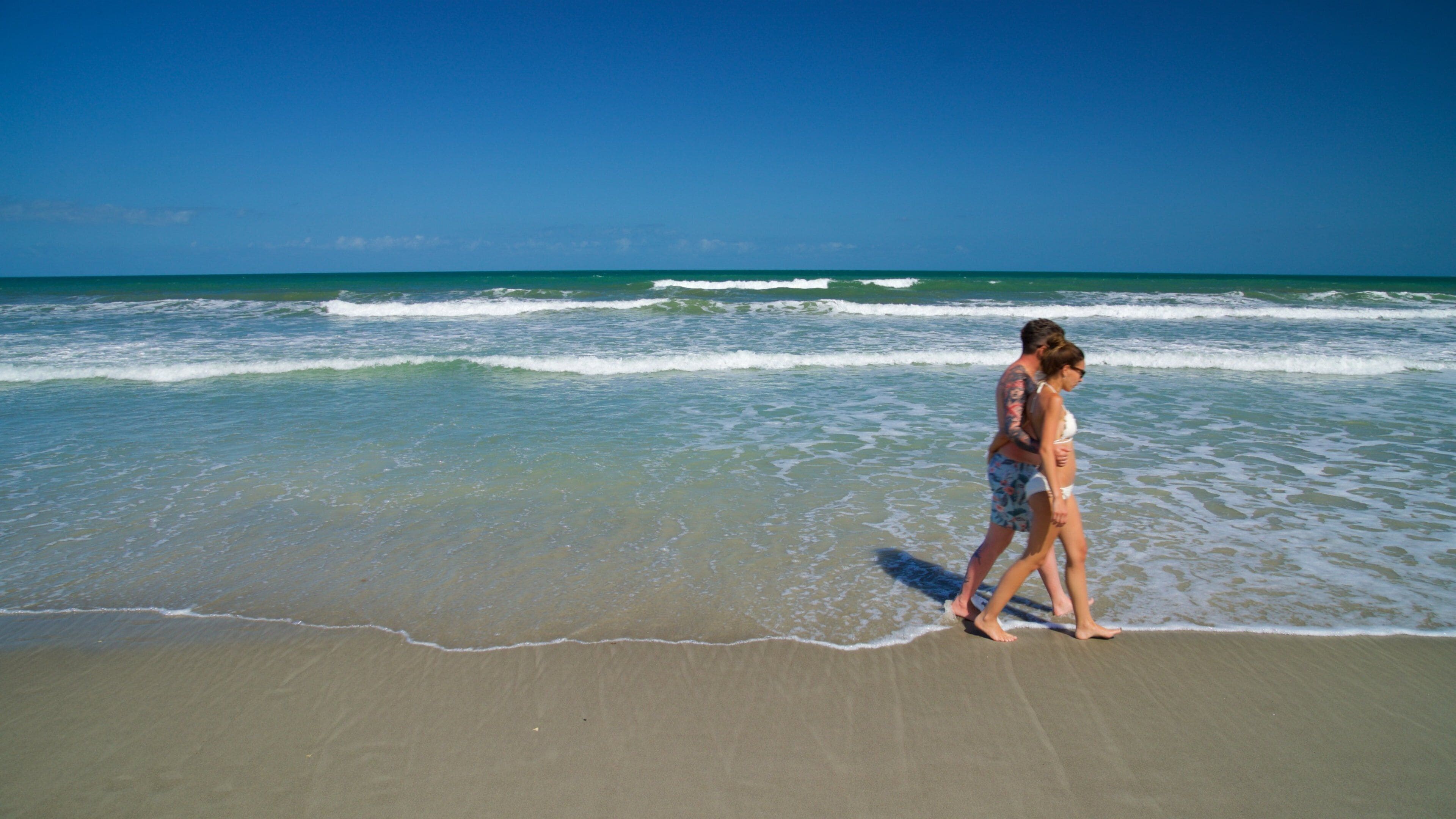 Cocoa Beach showing a sandy beach and general coastal views as well as a couple