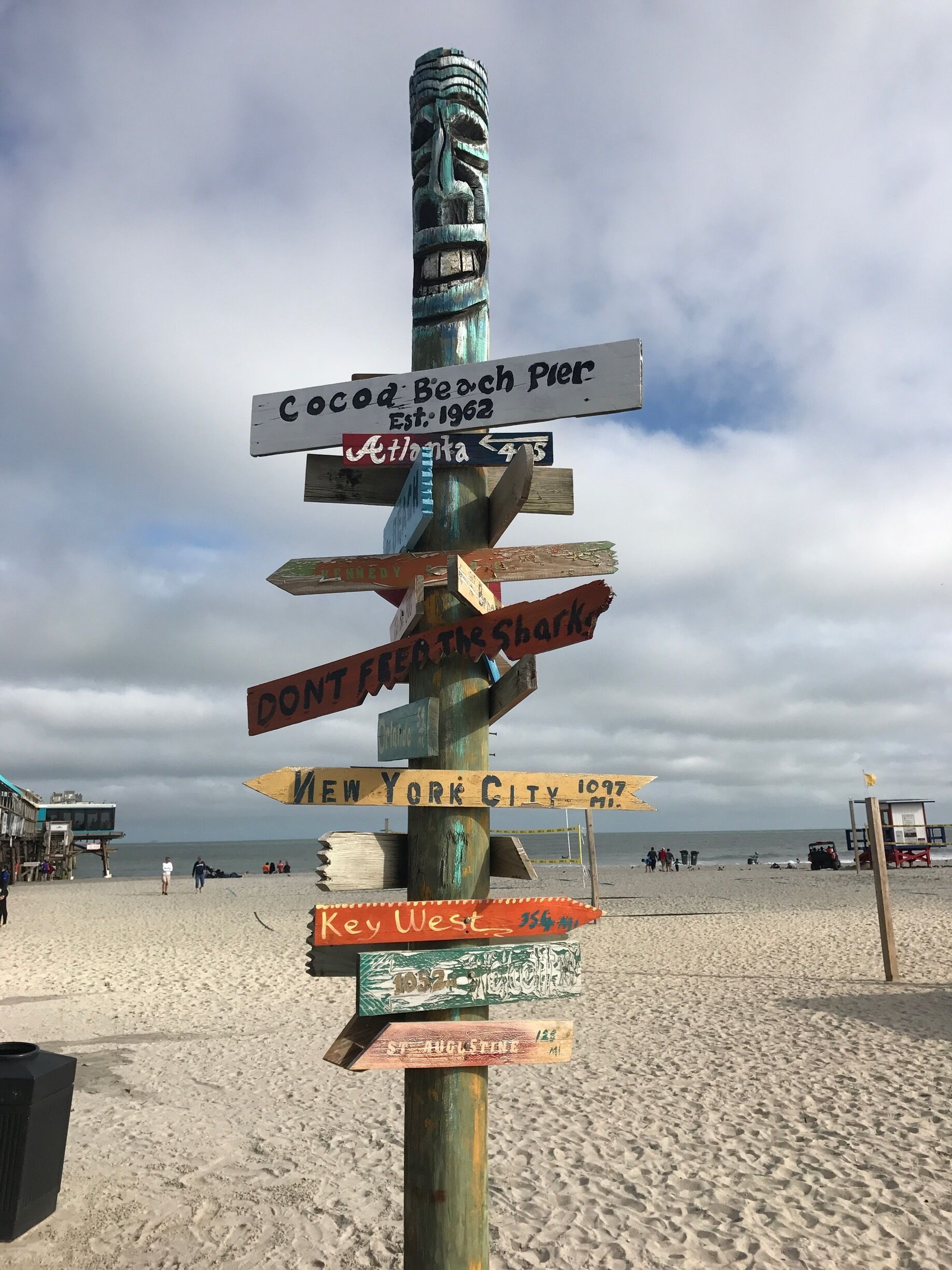 A wooden signpost with multiple directional signs pointing to various destinations.