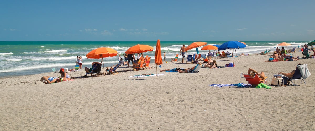 Cocoa Beach showing a beach and general coastal views as well as a small group of people
