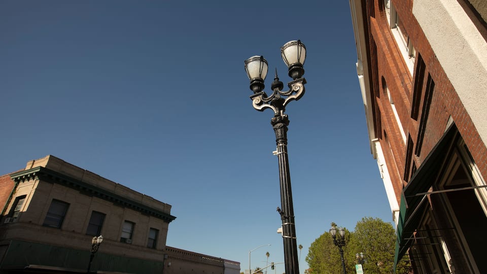 A street lamp, a brick building, and a clear blue sky.