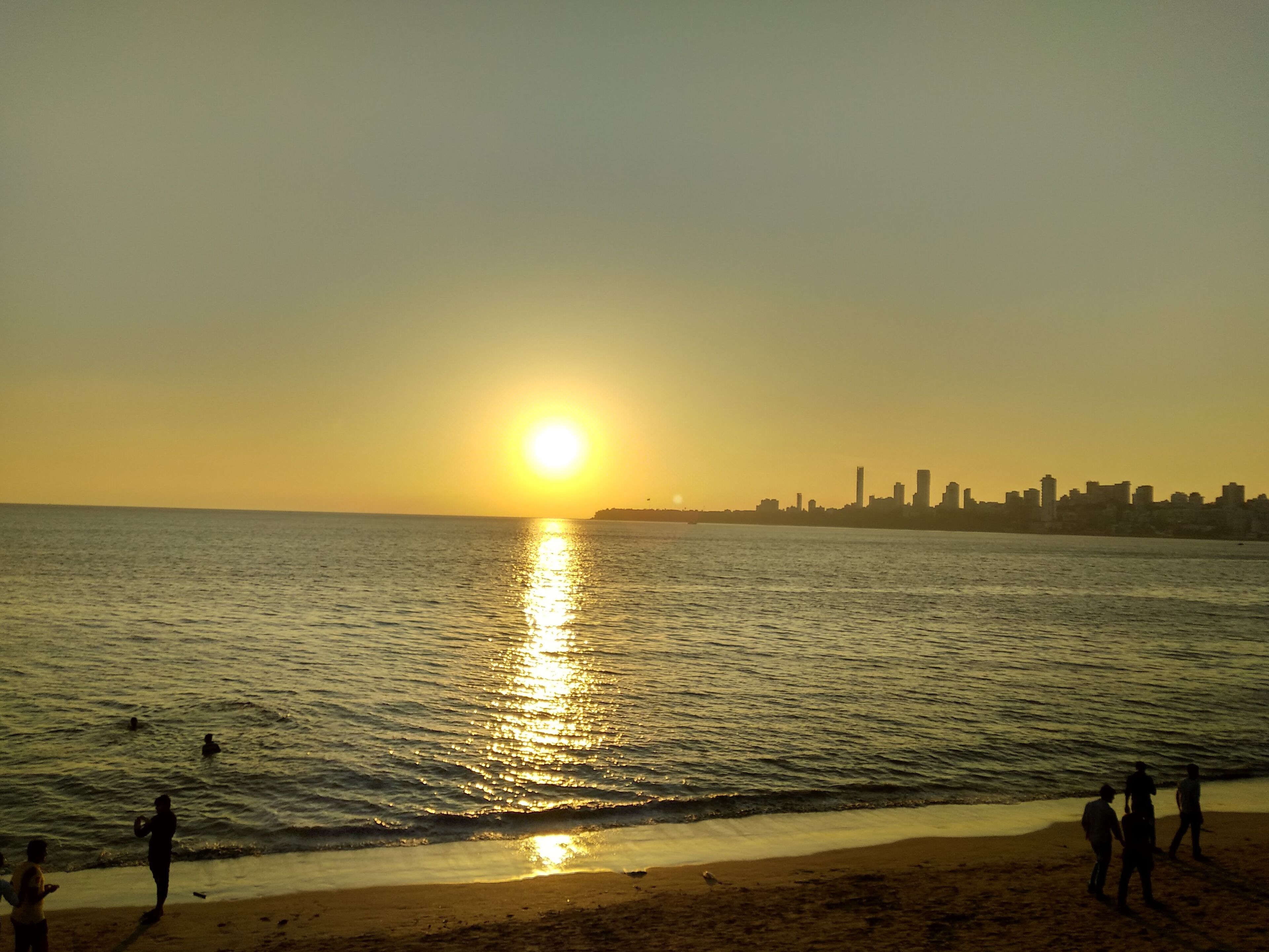 Enjoying sunset at Marine Drive Mumbai. It appears as if sun is about to touch the city line.. (just imagining)