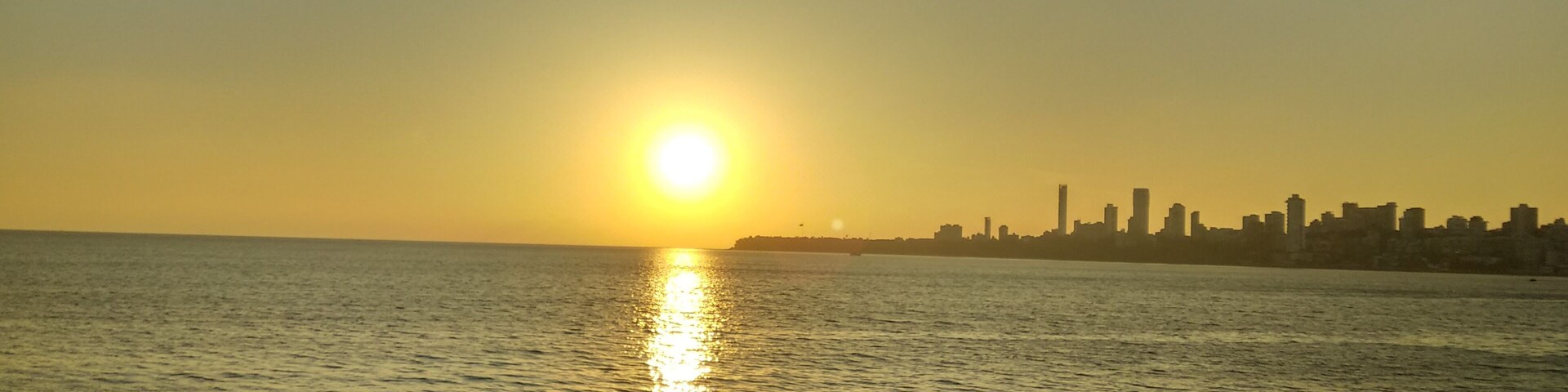 Enjoying sunset at Marine Drive Mumbai. It appears as if sun is about to touch the city line.. (just imagining)