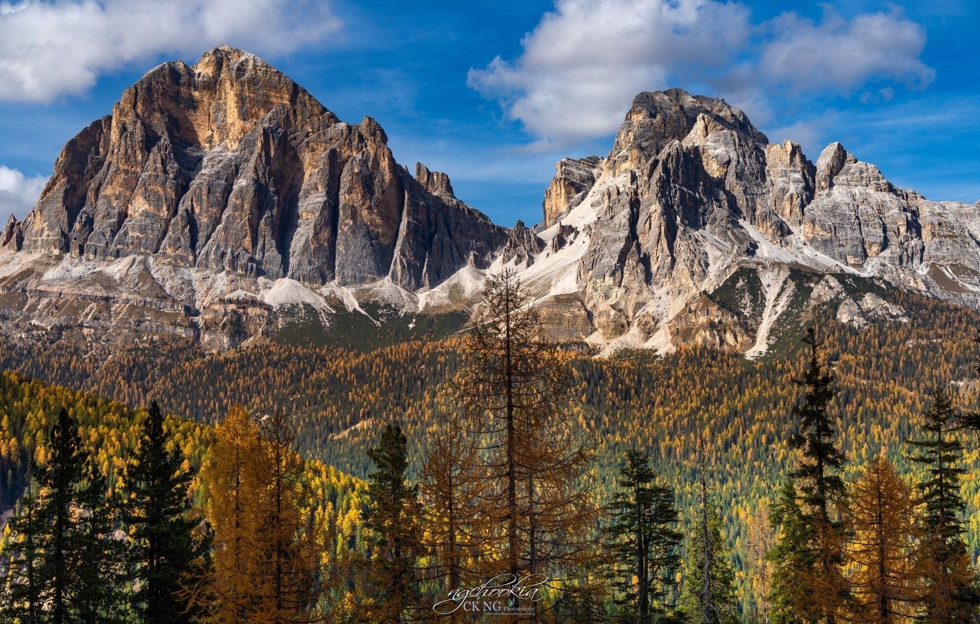 A mountain range with prominent peaks and a forested valley below.