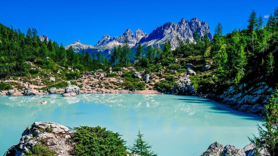 A mountain lake surrounded by rocky terrain and dense forest.
