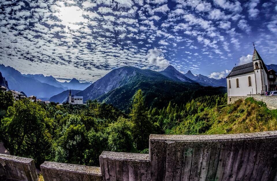 A church on a hill with mountains in the background.