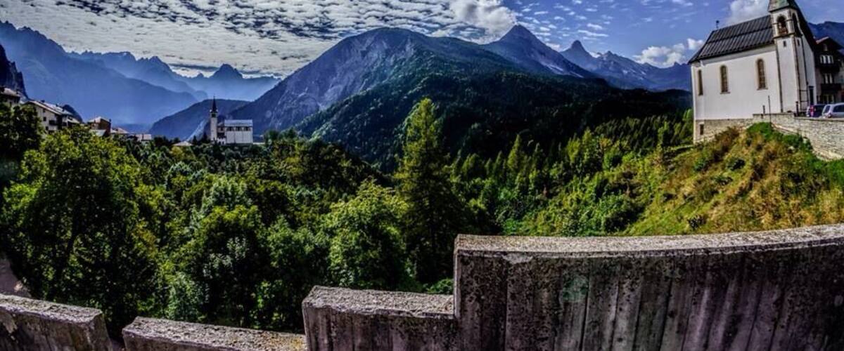 A church on a hill with mountains in the background.