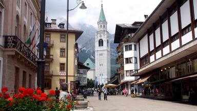 Una plaza urbana con una imponente torre de iglesia, calles empedradas y edificios tradicionales.