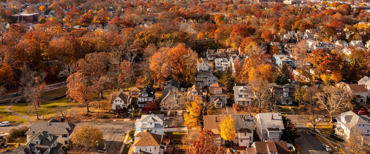 A suburban area with autumn-colored trees and houses.
