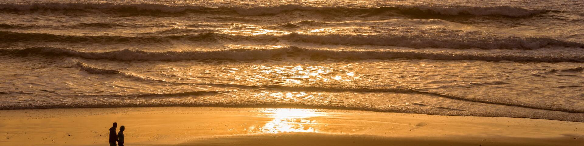 Silhouettes of a couple enjoying the sunset on the atlantic ocean, Lacanau France
