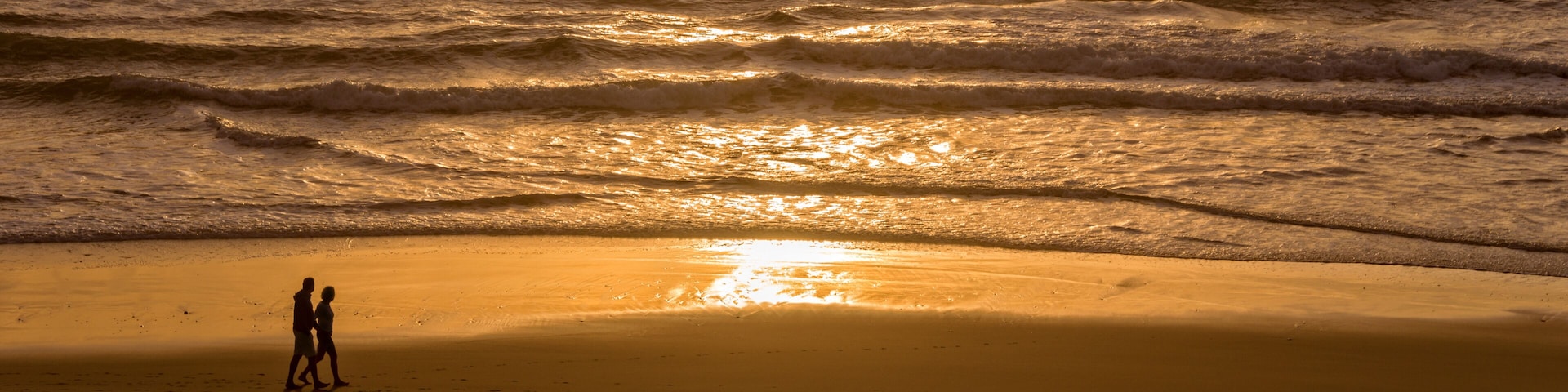 Silhouettes of a couple enjoying the sunset on the atlantic ocean, Lacanau France
