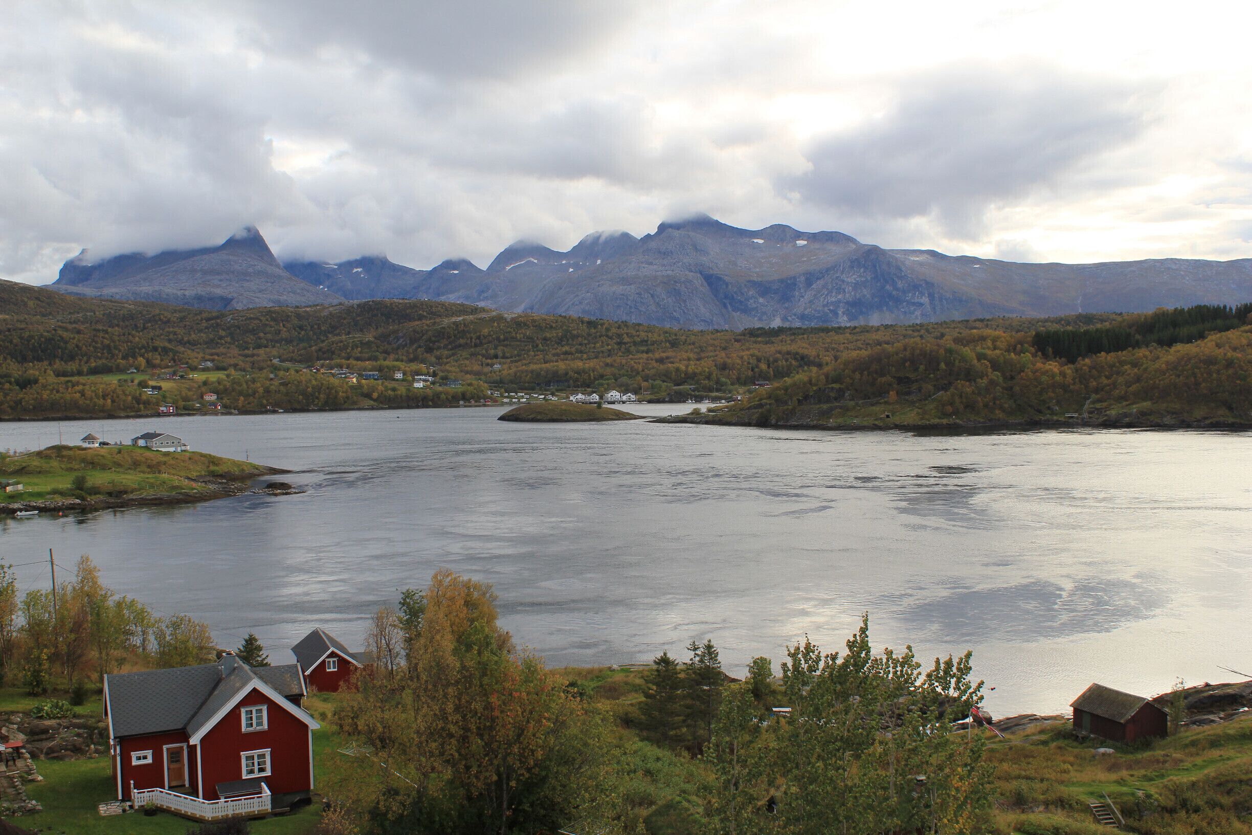 A lake surrounded by mountains and houses.