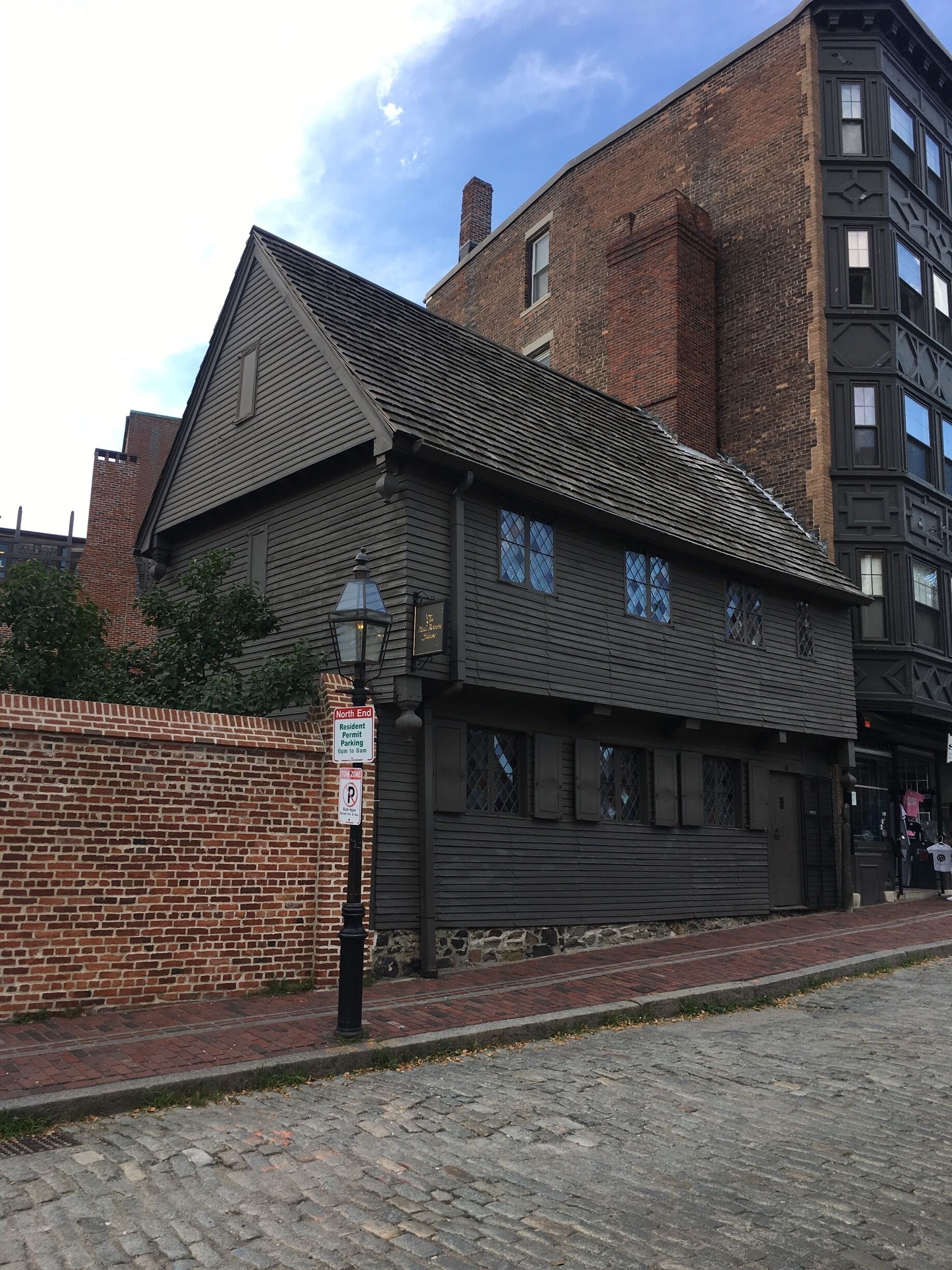 A historic building with a dark wooden facade and a brick chimney.