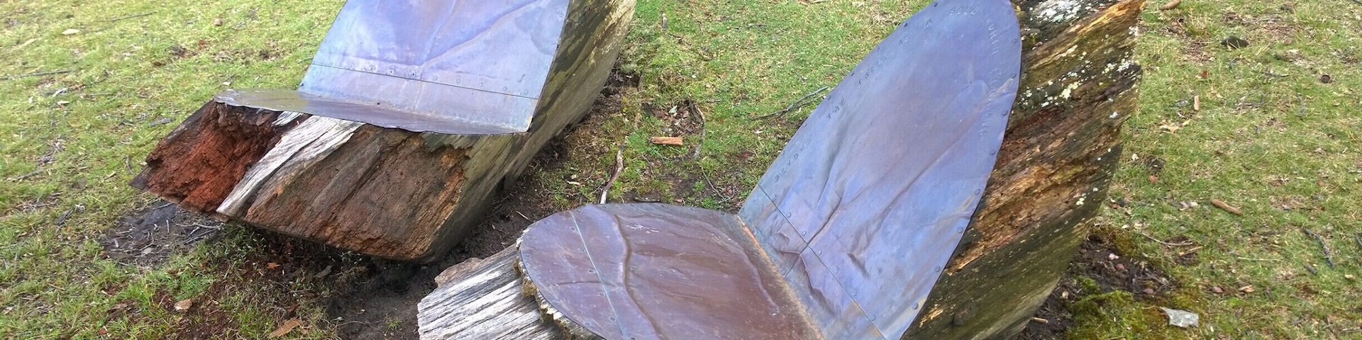 A couple of chairs made a tree stump and some bronze flashing overlooking the lake.
Built in 1848, Forest Hills Cemetery is a historic 275-acre cemetery, greenspace, arboretum and sculpture garden located in the Jamaica Plain neighborhood of Boston.