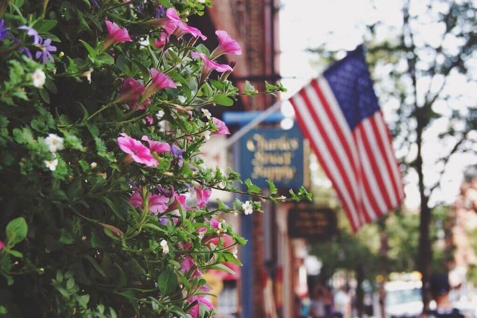 A street with a sign for 'Theater District' and an American flag.