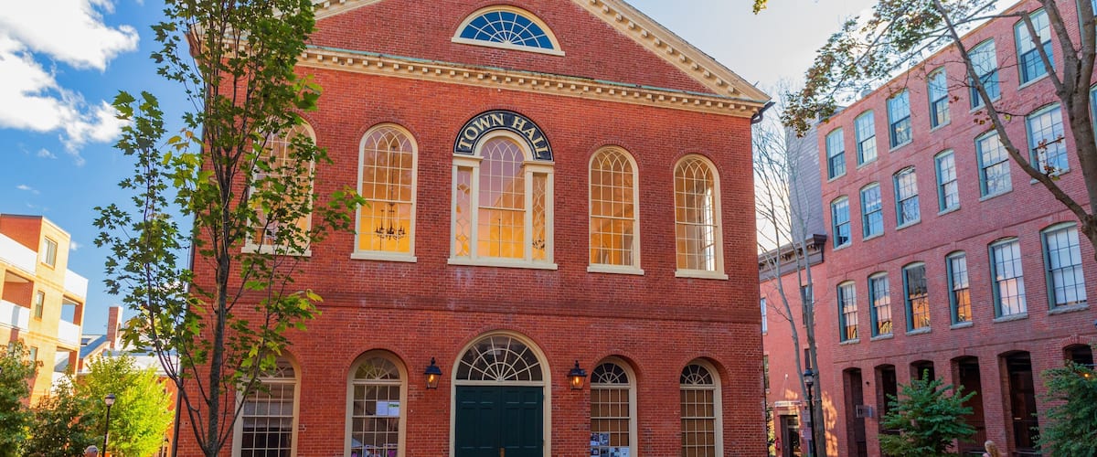A red brick building with arched windows and a Town Hall sign.