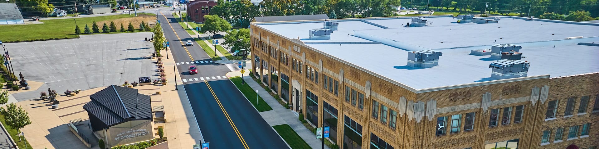 Corner view of ACD Automobile Museum with parking lots on bright sunny day aerial