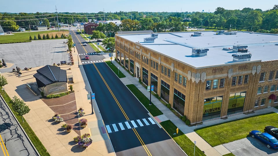 Corner view of ACD Automobile Museum with parking lots on bright sunny day aerial