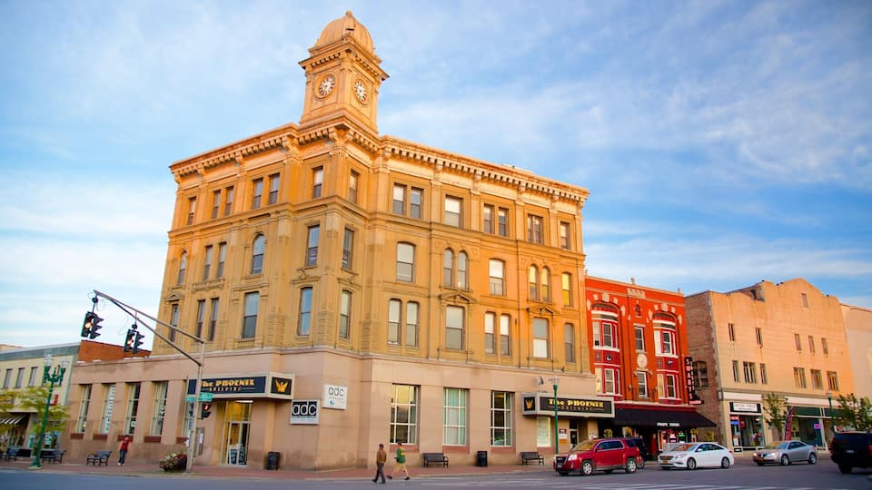 A historic building with a clock tower, The Phoenix Building, and a red building across the street.