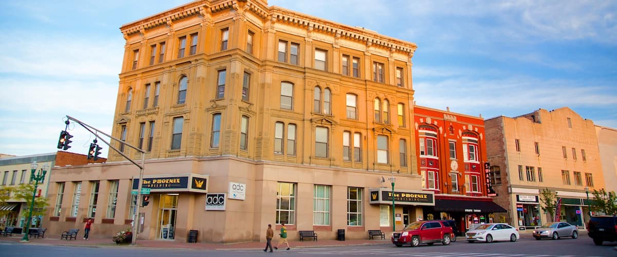 A historic building with a clock tower, The Phoenix Building, and a red building across the street.
