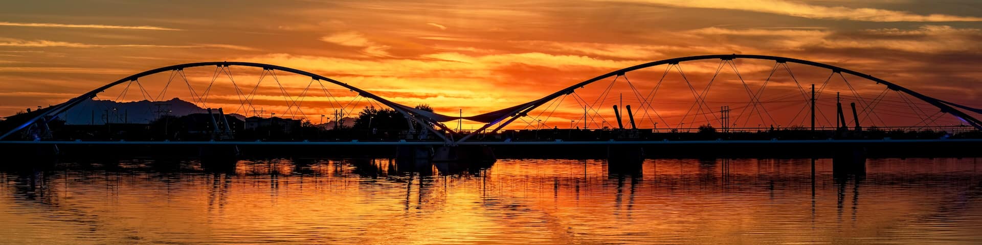 Footbridge across Tempe Town Lake in Tempe Arizona at dusk with sunset
