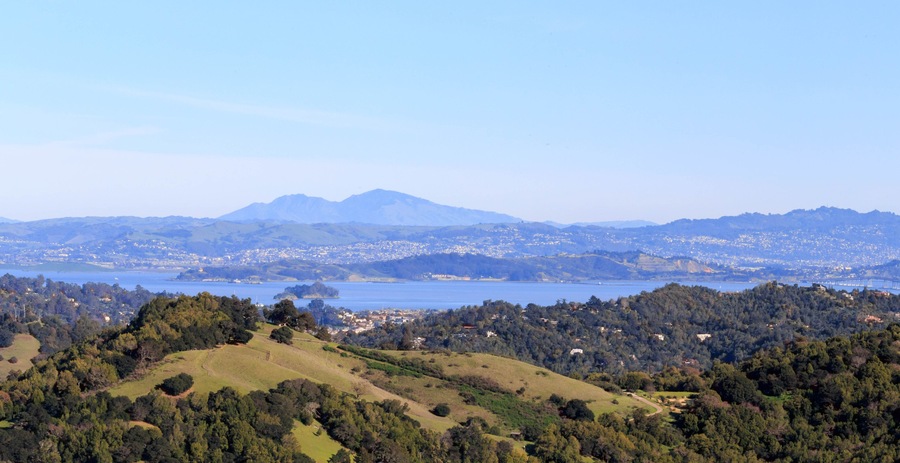 Paisagem costeira com uma cordilheira, um lago e uma cidade no vale.