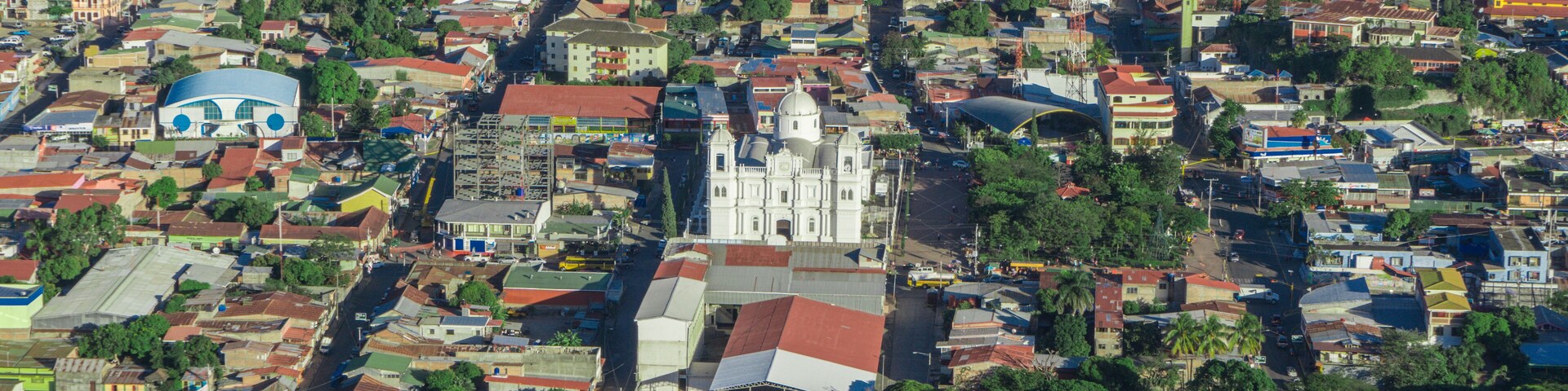 incredible aerial view of city surrounded by forest and mountains