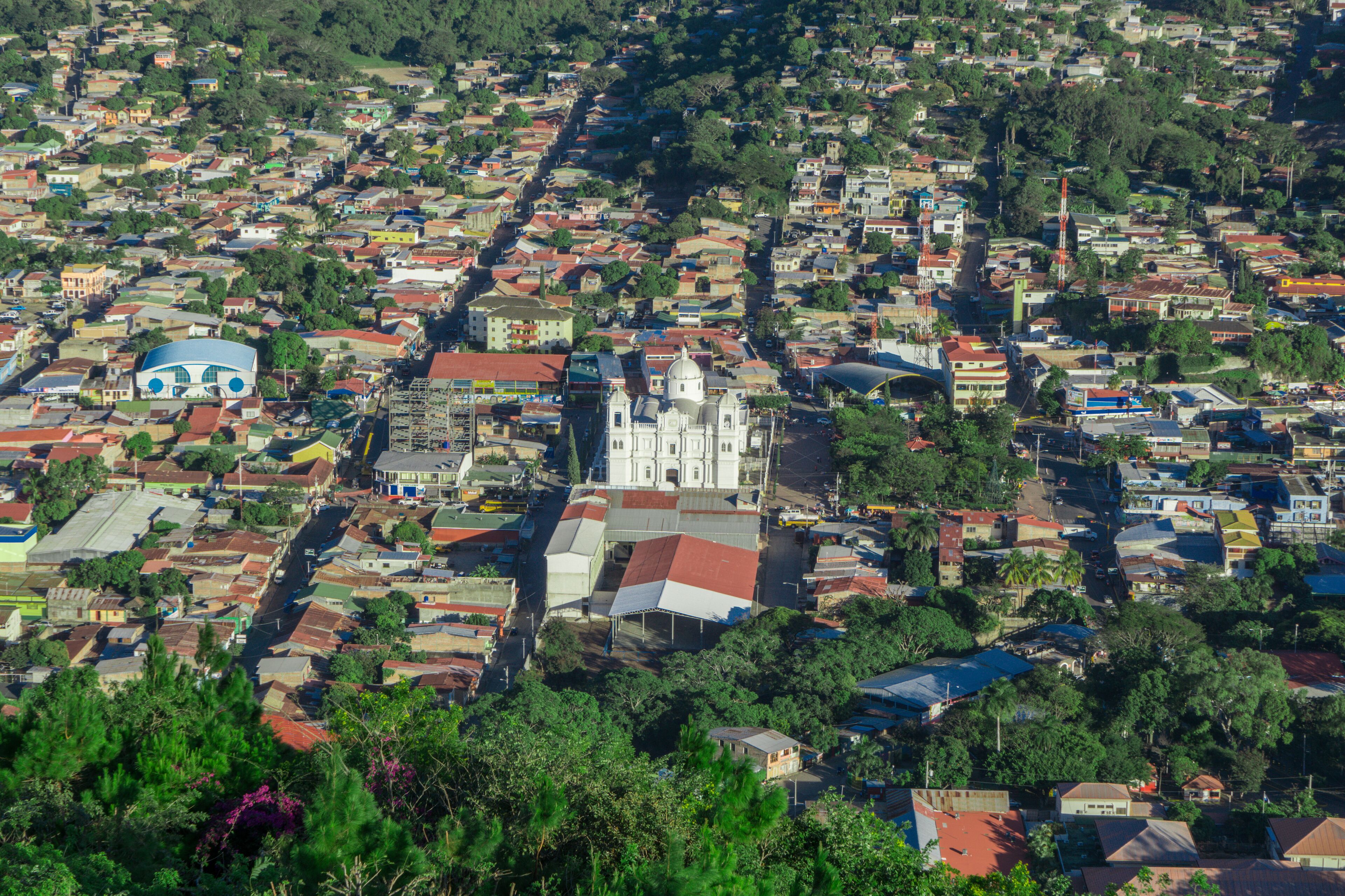 A densely populated urban area with a prominent white church and a blue dome structure.
