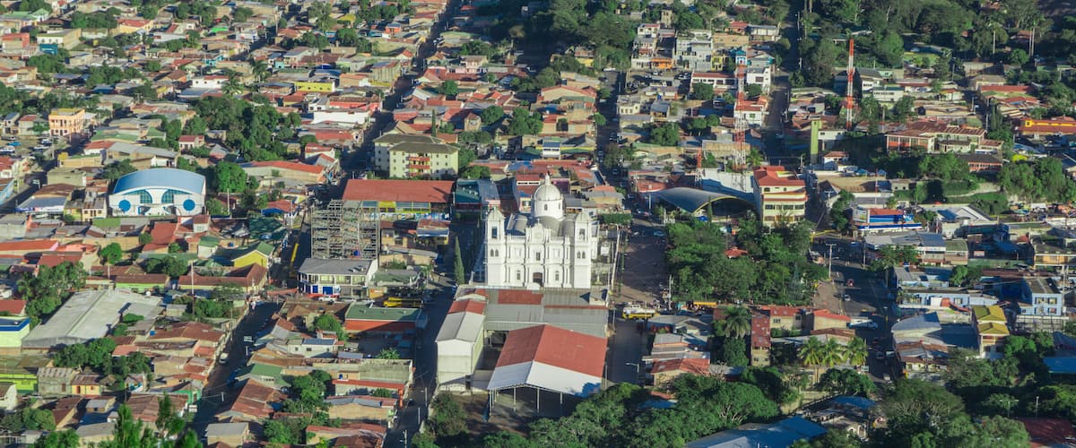 A densely populated urban area with a prominent white church and a blue dome structure.