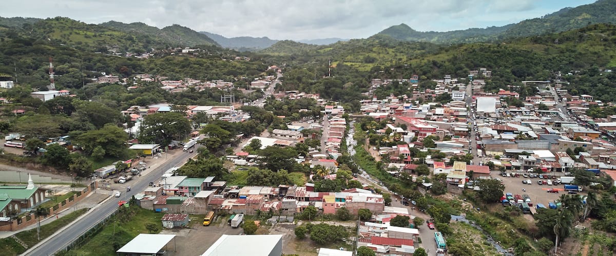 A town nestled in a valley with mountains in the background.