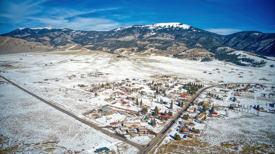 A snow-covered town with mountains in the background.