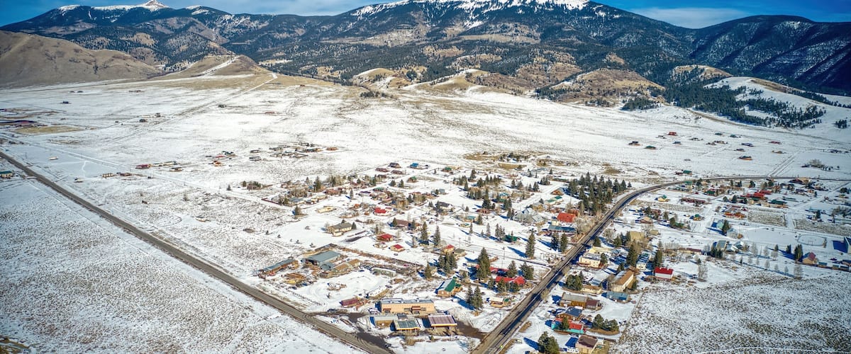 A snow-covered town with mountains in the background.