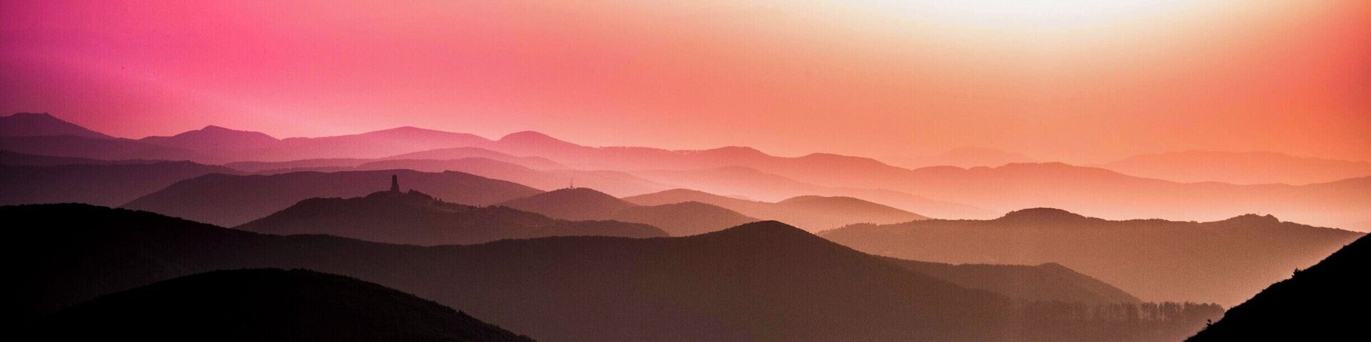 Cordillera montañosa con amanecer o atardecer.