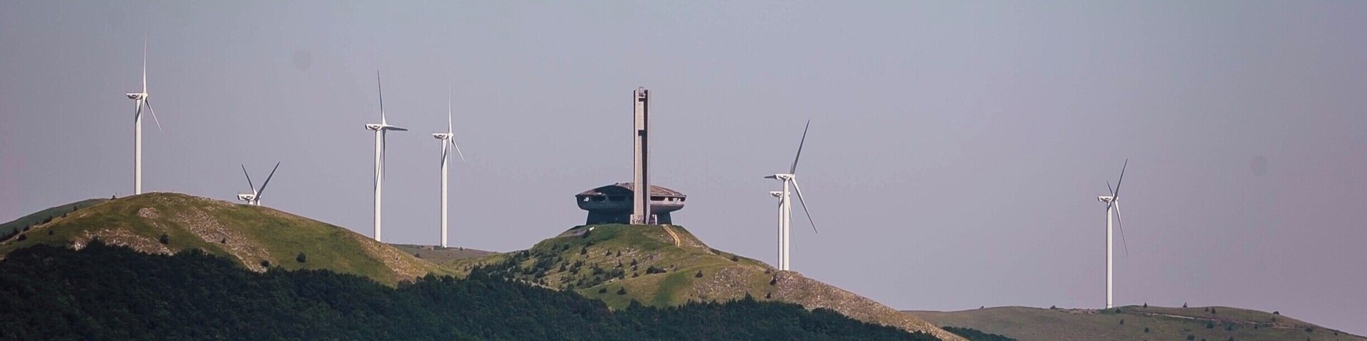 Paisagem com várias turbinas eólicas em colinas onduladas.