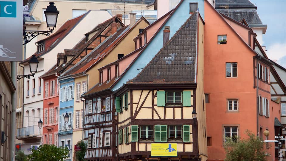 A row of colorful half-timbered buildings with a sign for 'Construction Franc Basso'.