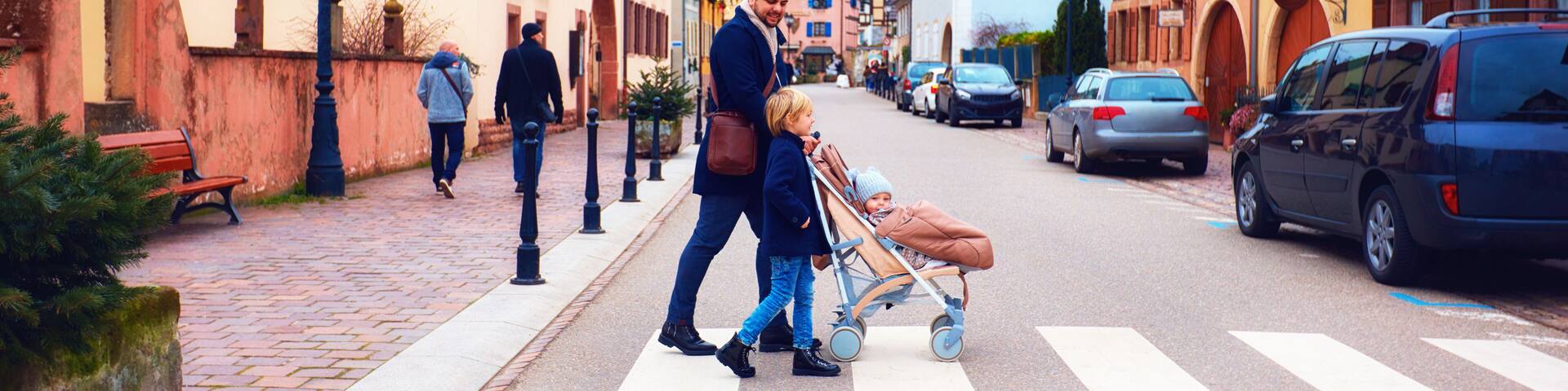 cute family crossing the street of Eguisheim village, France