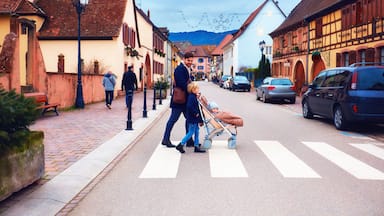 cute family crossing the street of Eguisheim village, France