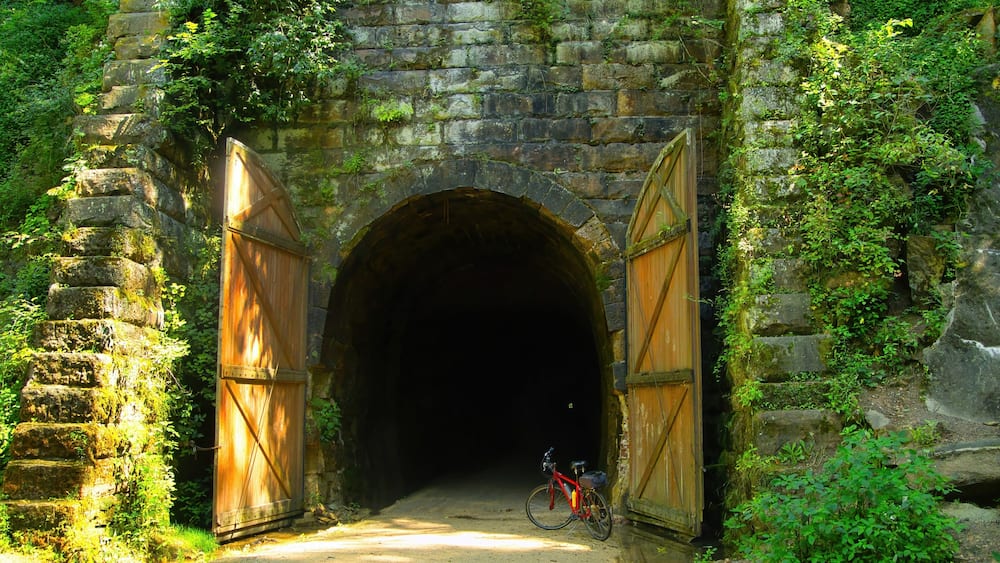 Large wooden doors stand at the entrance to one of three former train tunnels now used for recreation as the Elroy-Sparta State Trail near Sparta, WI.