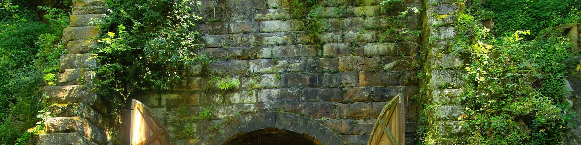 Large wooden doors stand at the entrance to one of three former train tunnels now used for recreation as the Elroy-Sparta State Trail near Sparta, WI.