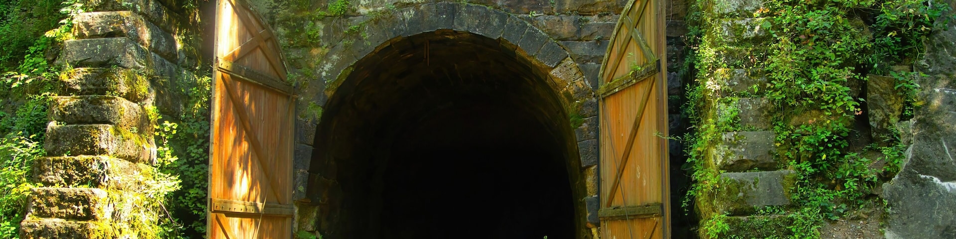 Large wooden doors stand at the entrance to one of three former train tunnels now used for recreation as the Elroy-Sparta State Trail near Sparta, WI.