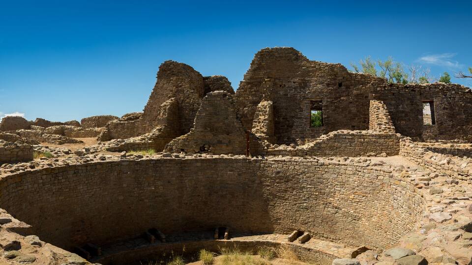 Ancient ruins with stone walls and a large circular structure.
