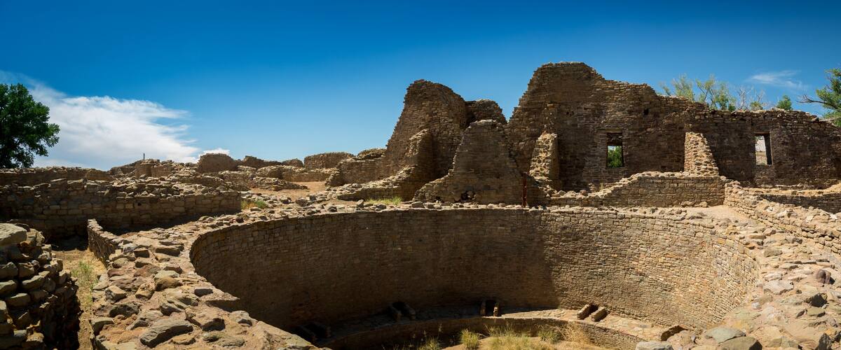 Ancient ruins with stone walls and a large circular structure.