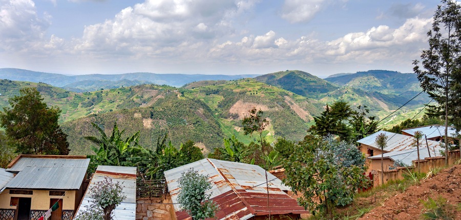 A steep hill in the Muvumba river valley in Rwanda, entirely covered with terraced fields and dotted with houses.