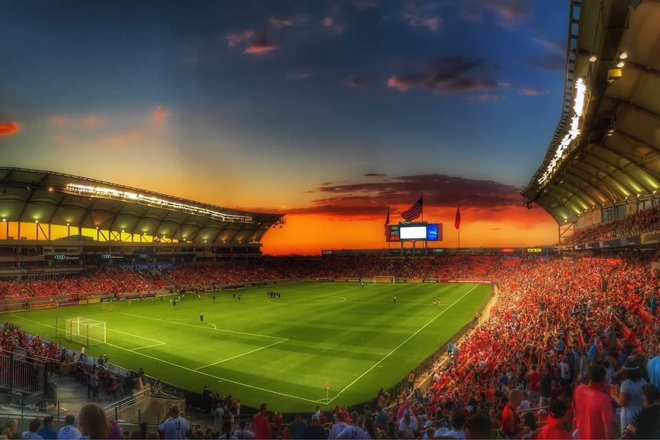 A stadium filled with spectators during a sunset.