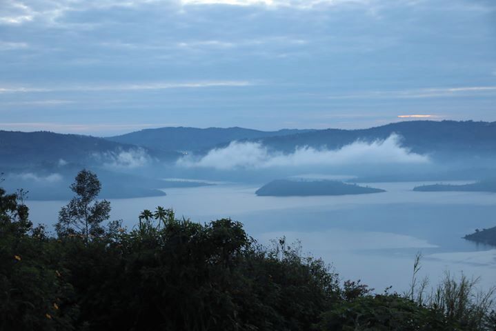 A misty lake surrounded by mountains and dense forest.