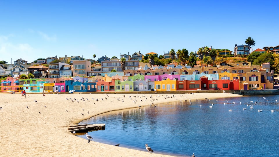 A colorful coastal town with a sandy beach and a calm sea.