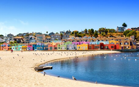 A colorful coastal town with a sandy beach and a calm sea.