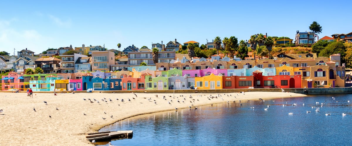 A colorful coastal town with a sandy beach and a calm sea.