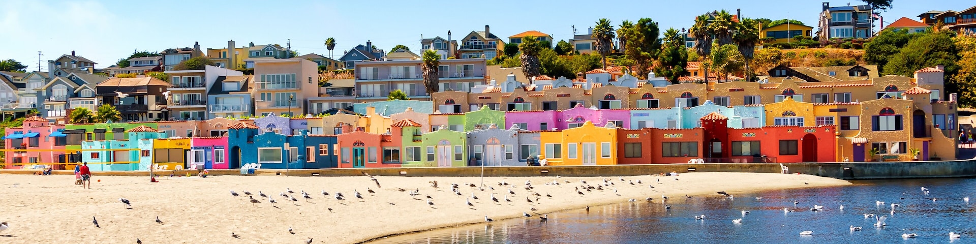 A colorful coastal town with a sandy beach and a calm sea.